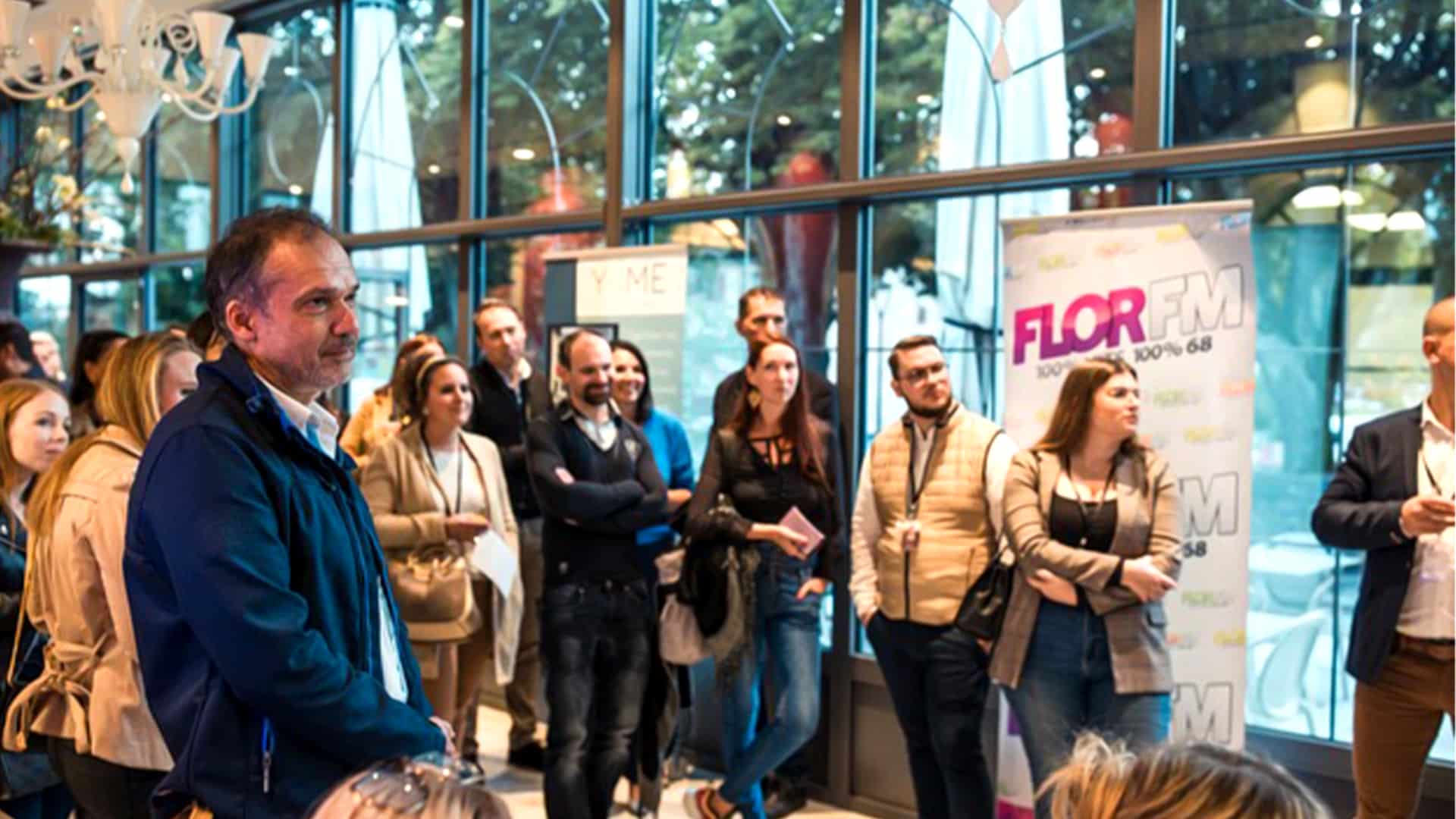 Participants attentifs lors d’un événement Bo Réso, en partenariat avec la radio locale Flor FM, dans un cadre lumineux et dynamique propice au réseautage.
