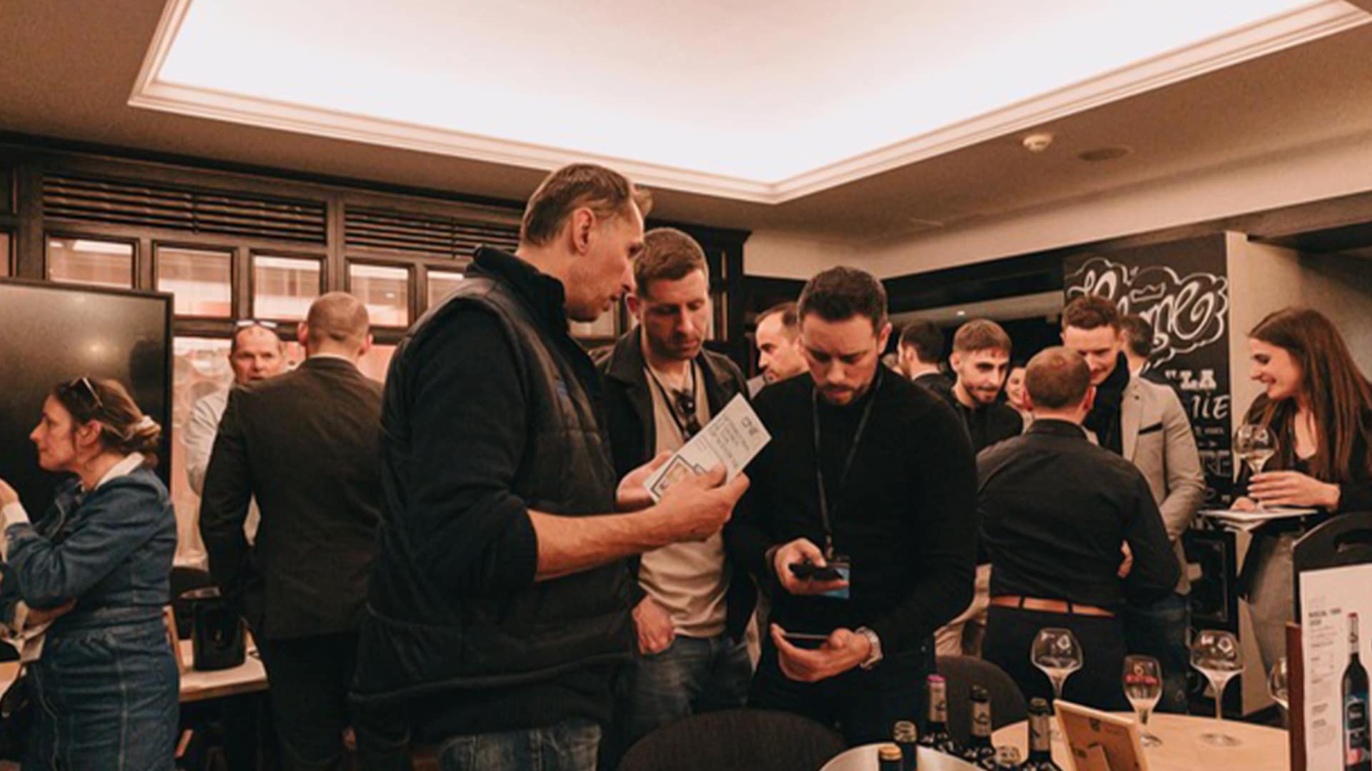 Des professionnels échangent cartes, projets et conseils autour d’un verre dans une ambiance détendue et professionnelle lors d’une soirée Le Bo Réso.